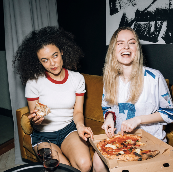 two women eating pizza