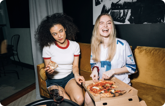 two women eating pizza