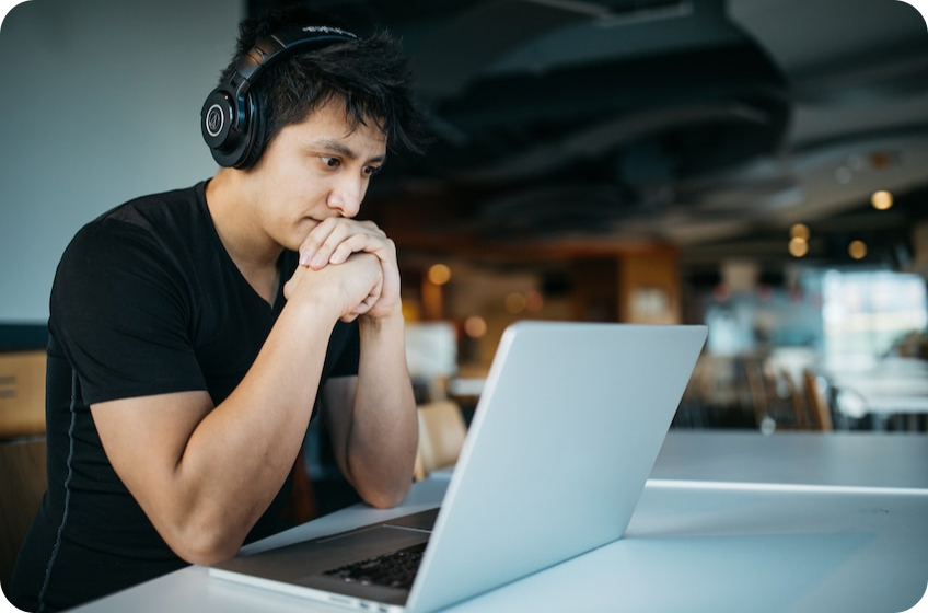 Man with headphones looking at his laptop