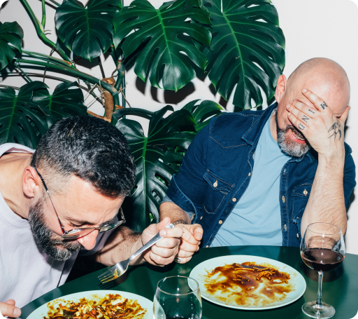Two men laughing while having dinner