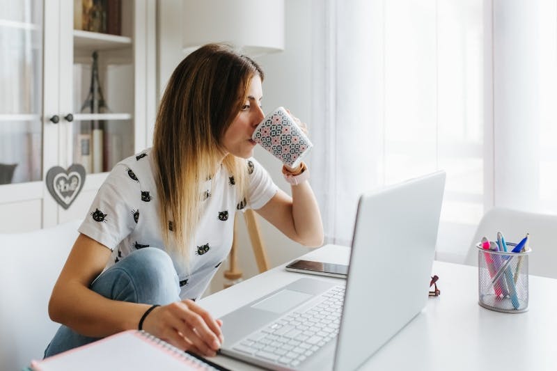 woman drinking coffee figuring out which student loans to pay off first